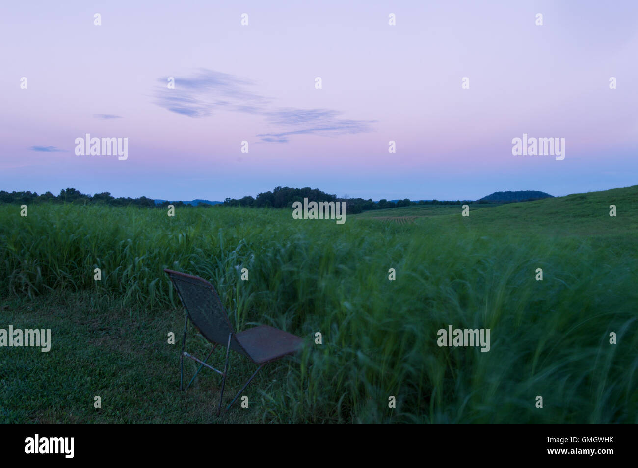 A chair sits in the grass at sunrise at the Abbey of Gethsemani, a Trappist monastery in Kentucky Stock Photo