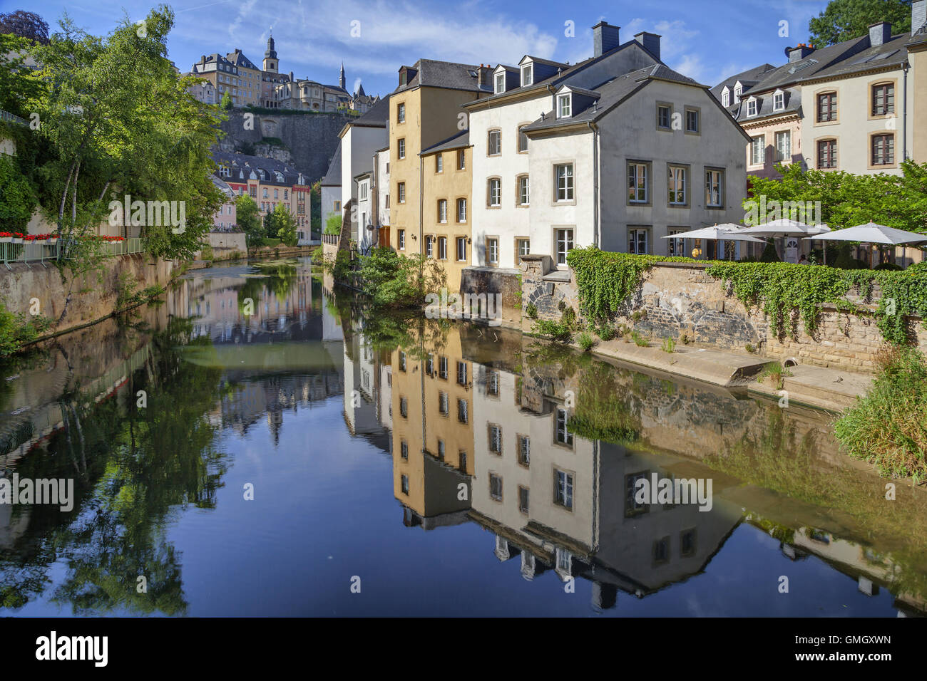 Old houses reflecting in smooth water of Alzette river in Luxembourg Stock Photo