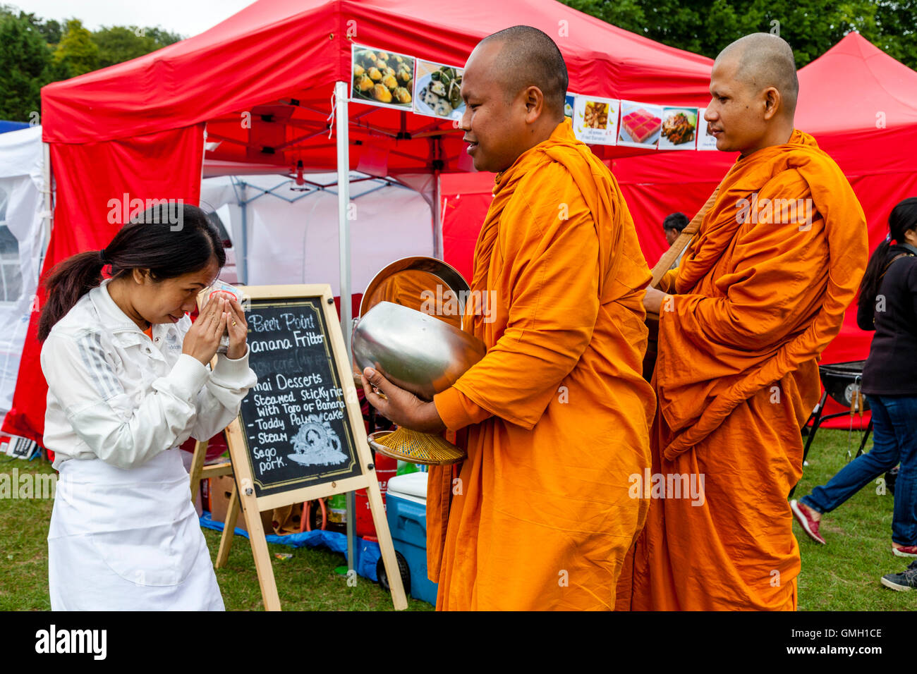 Thai People Offer Food To Two Monks At The Brighton Thai Festival