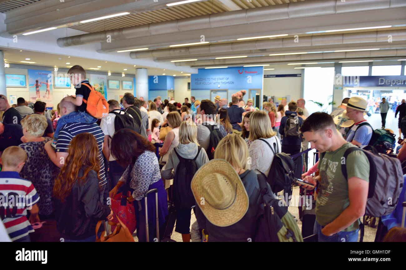 People waiting to check bags at airport Stock Photo