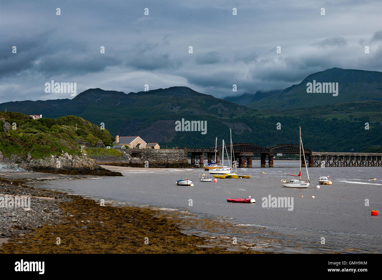 Barmouth harbour with Barmouth Bridge carrying Cambrian Coast Railway and Cader Idris bayond. Stock Photo