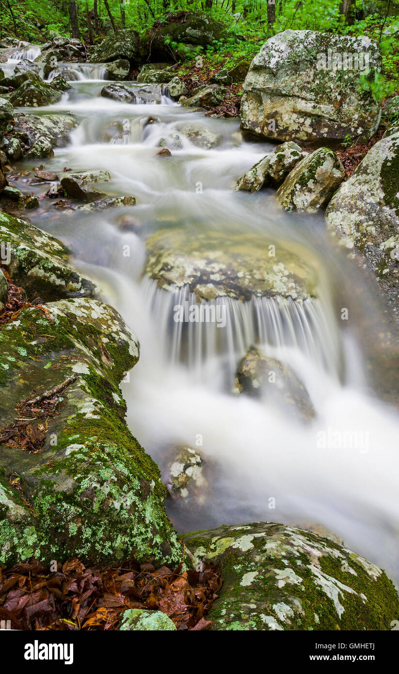 A waterfall cascades over moss covered limestone in the Arkansas Ozark Mountains after a spring rain. Stock Photo