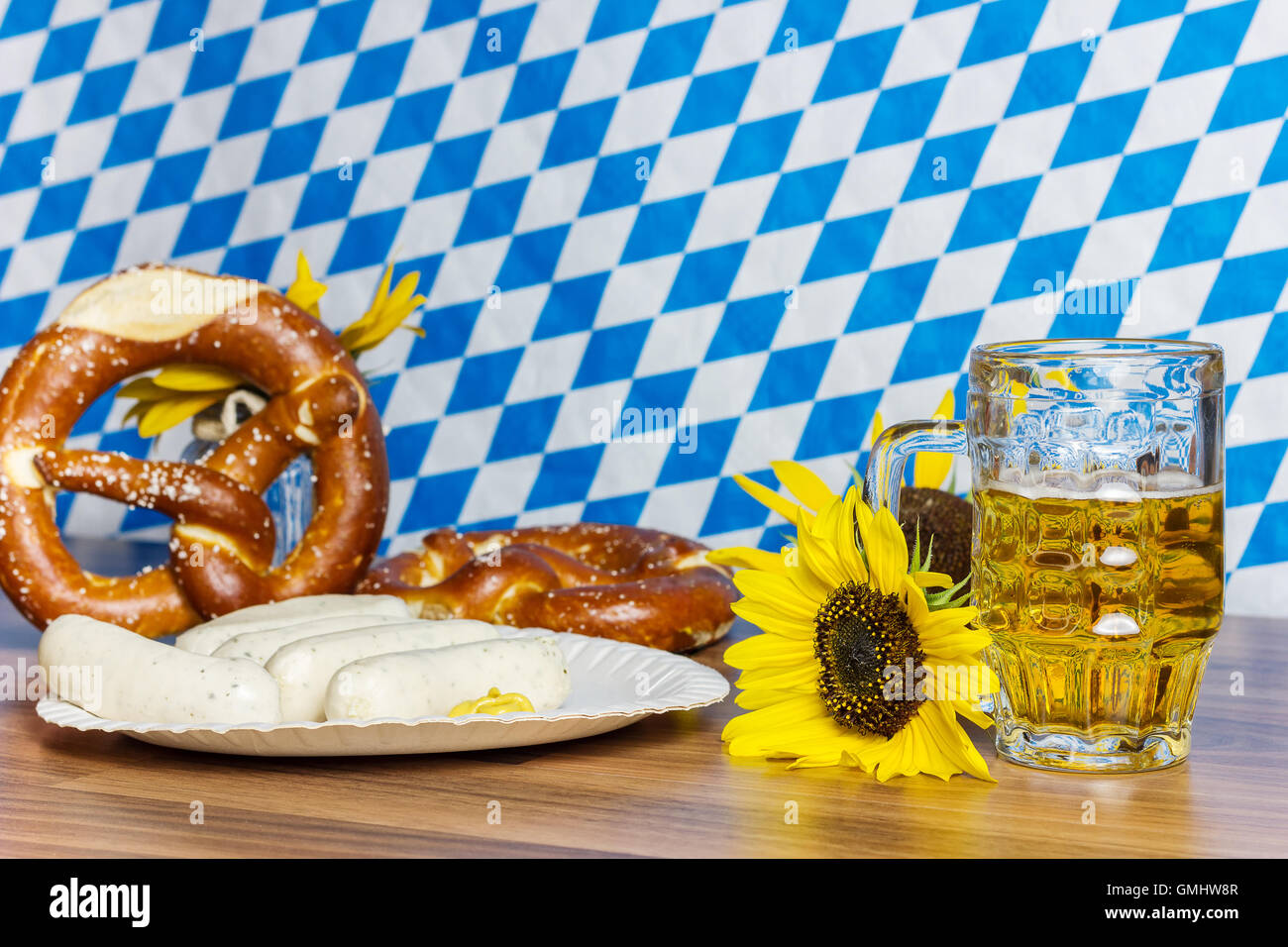 glass full of beer with prezels and traditional Bavarian sausage in front of bavarian flag Stock Photo
