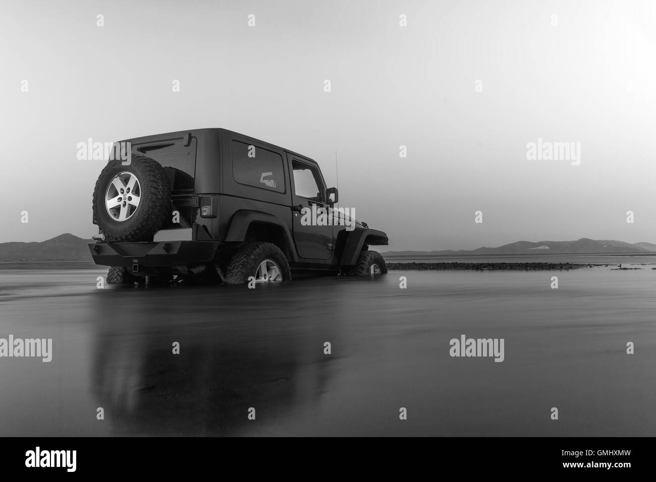 Jeep 4x4 in black and white. Jeep got stuck in the mud at a wetland. Stock Photo