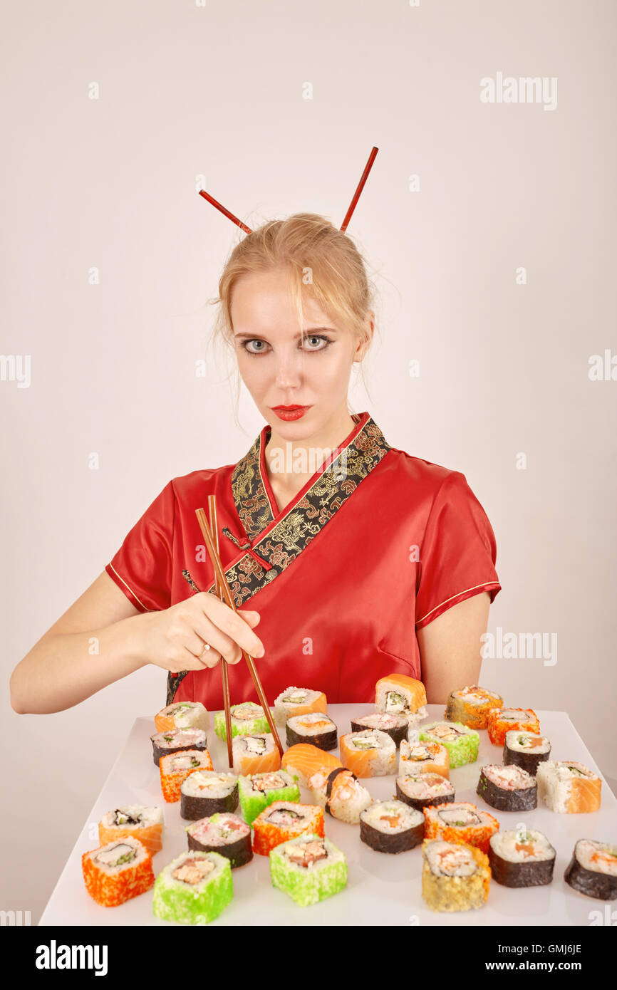 serious girl in the Japanese clothes with sushi Stock Photo Alamy