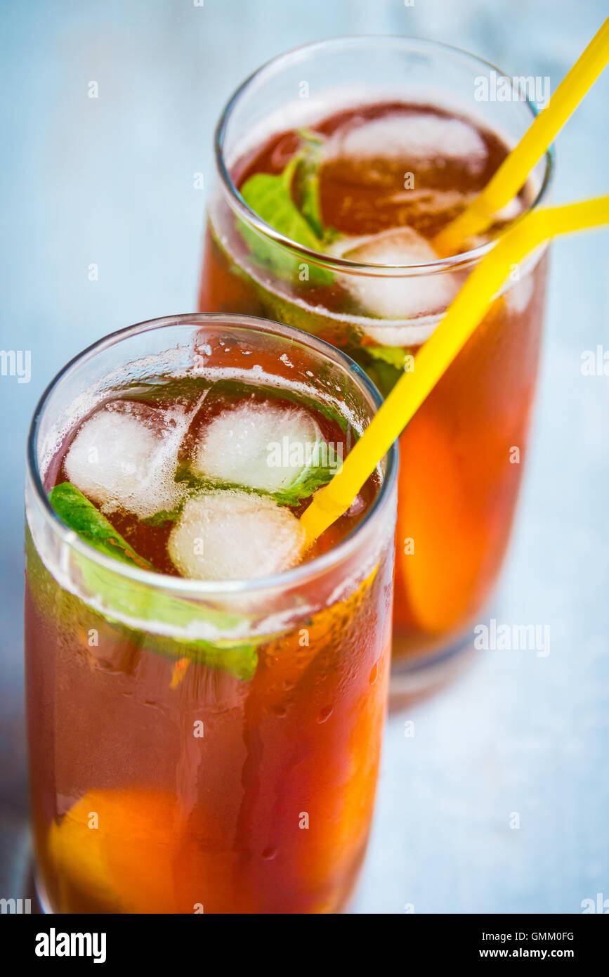 Close up of glasses with homemade ice tea, peach flavored. Freshly cut peach slices for arrangement. Top view. Stock Photo