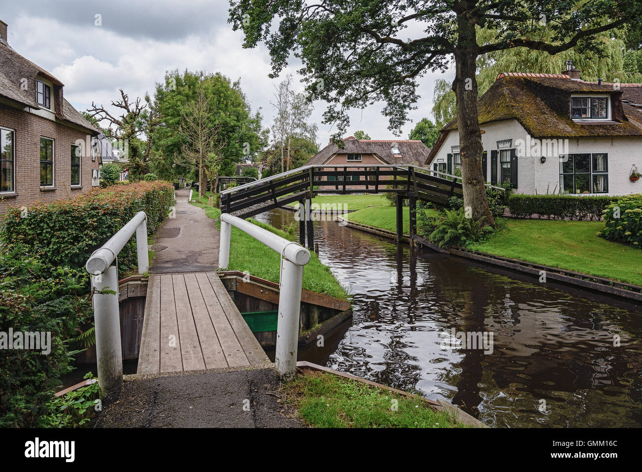 Giethoorn in The Netherlands is known for its bridges, waterways, thatched cottages  and punters and is also known as Dutch Venice Stock Photo