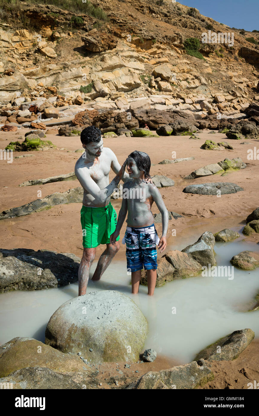 Rubbing each other with healthy rassoul on the beach in Assila, Morocco Stock Photo