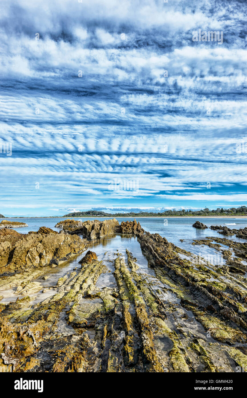 Rocky Coastline and mackerel sky at Candlagan Creek, Mossy Point, New South Wales, NSW, Australia Stock Photo