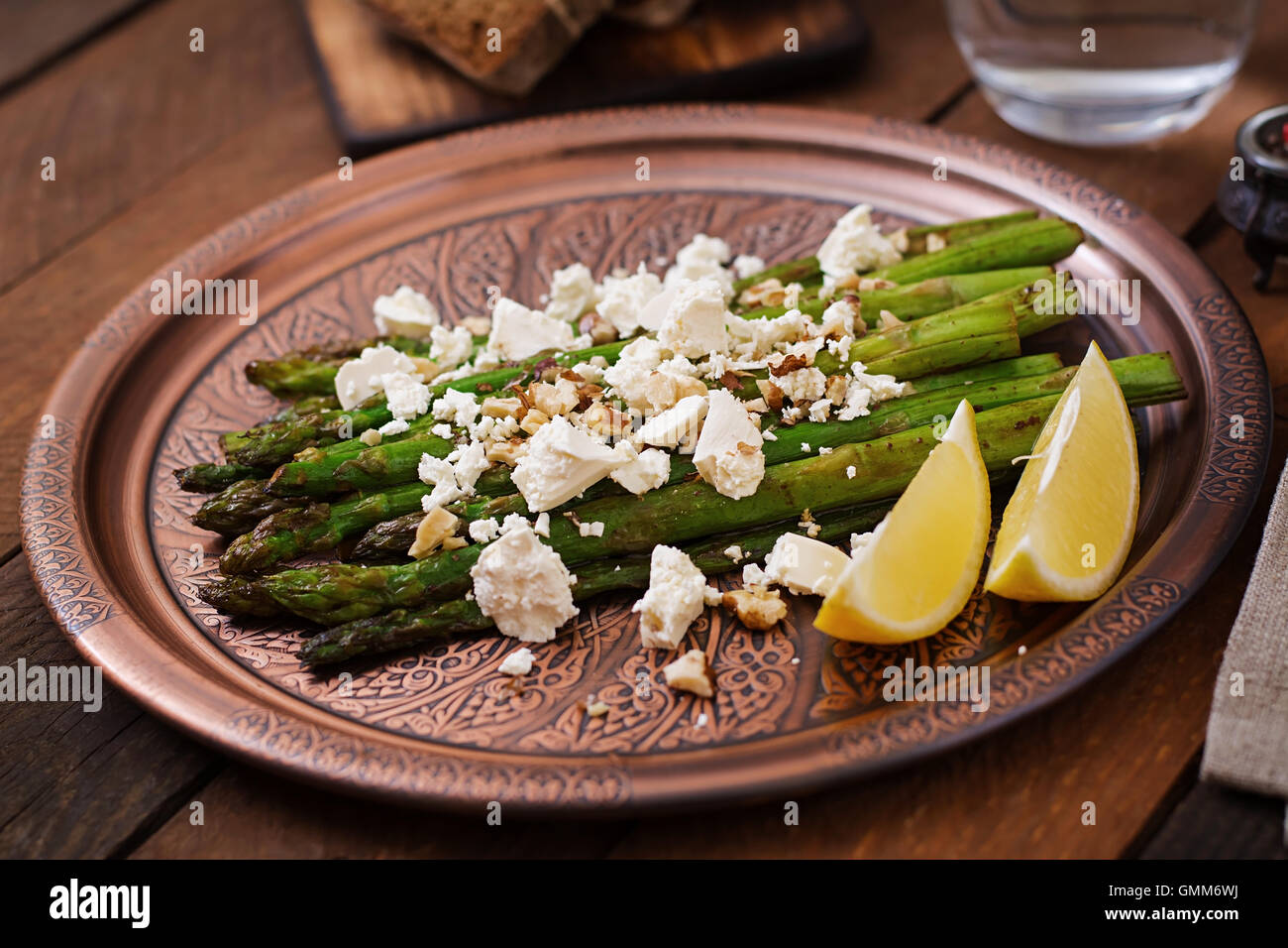Warm salad of roasted asparagus, feta cheese, nuts, flavored with lemon juice Stock Photo