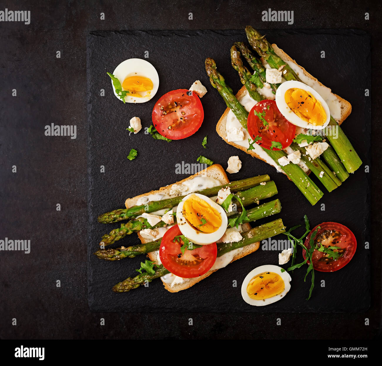 Sandwiches with caramelized asparagus, feta cheese, tomatoes and eggs
