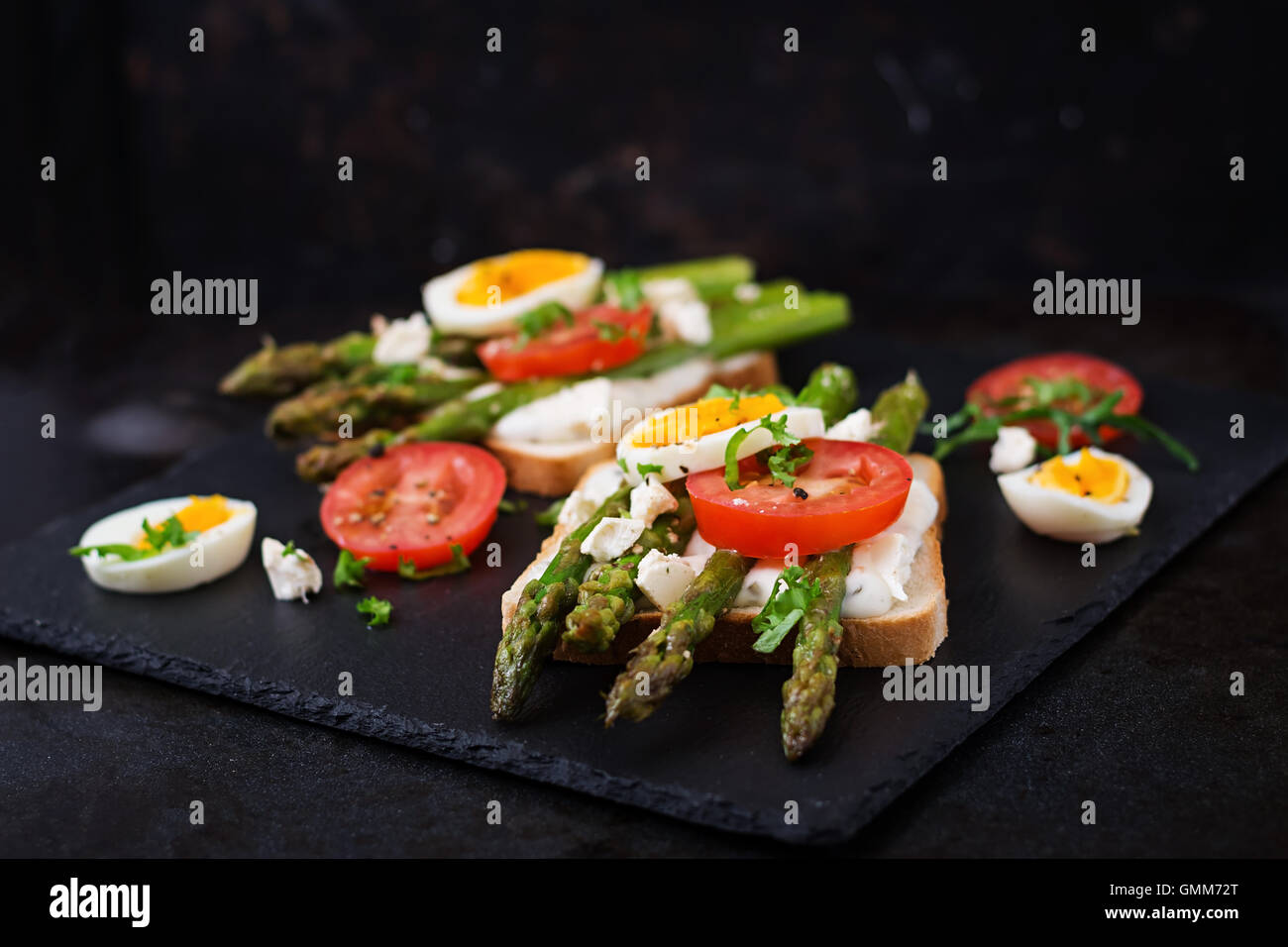Sandwiches with caramelized asparagus, feta cheese, tomatoes and eggs