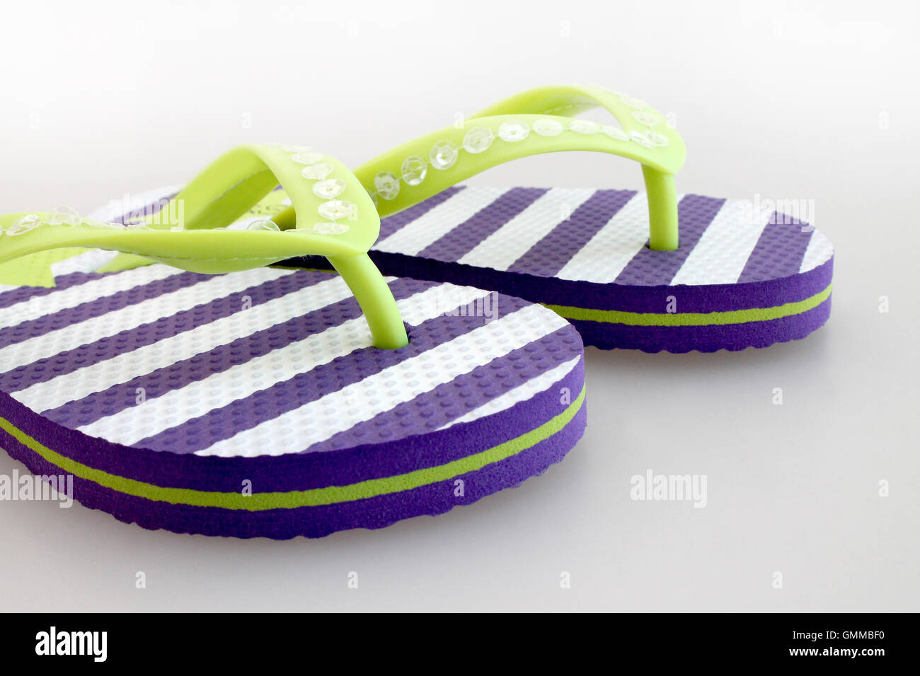 Pair of striped flip flops on white background Stock Photo - Alamy