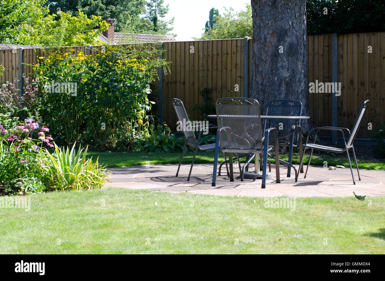 Patio with table and chairs in garden Stock Photo - Alamy