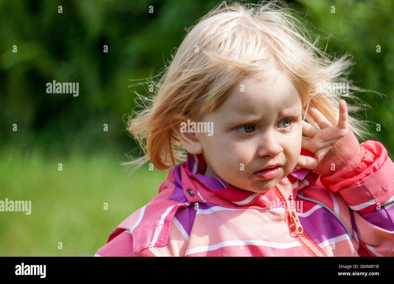 Sad little girl outside in the Garden Stock Photo