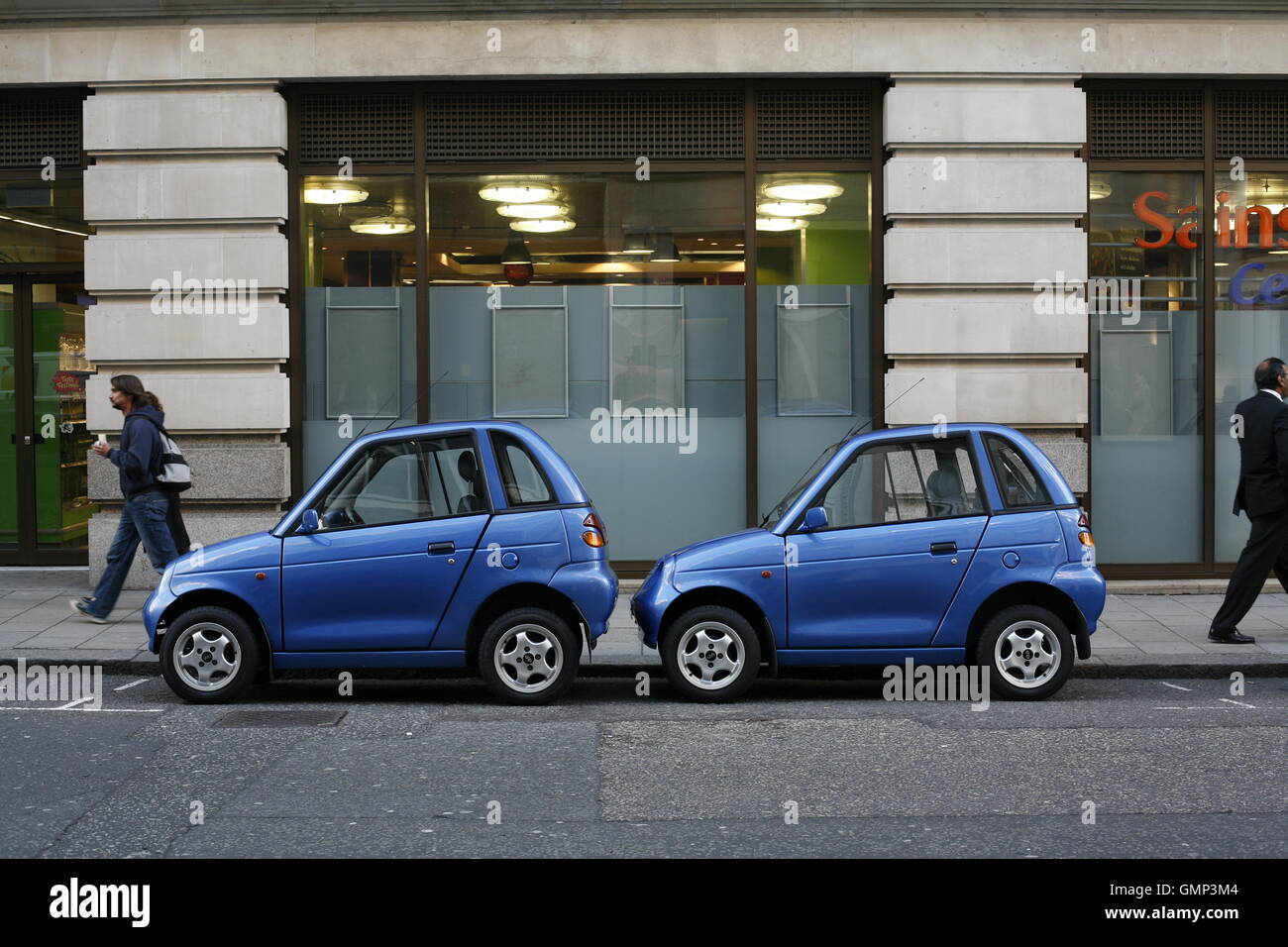 Two cars for one parking space in Berkeley Street. Despite a Rolls Royce dealership, tiny electric cars swarmed around Mayfair and Berkeley Square Stock Photo