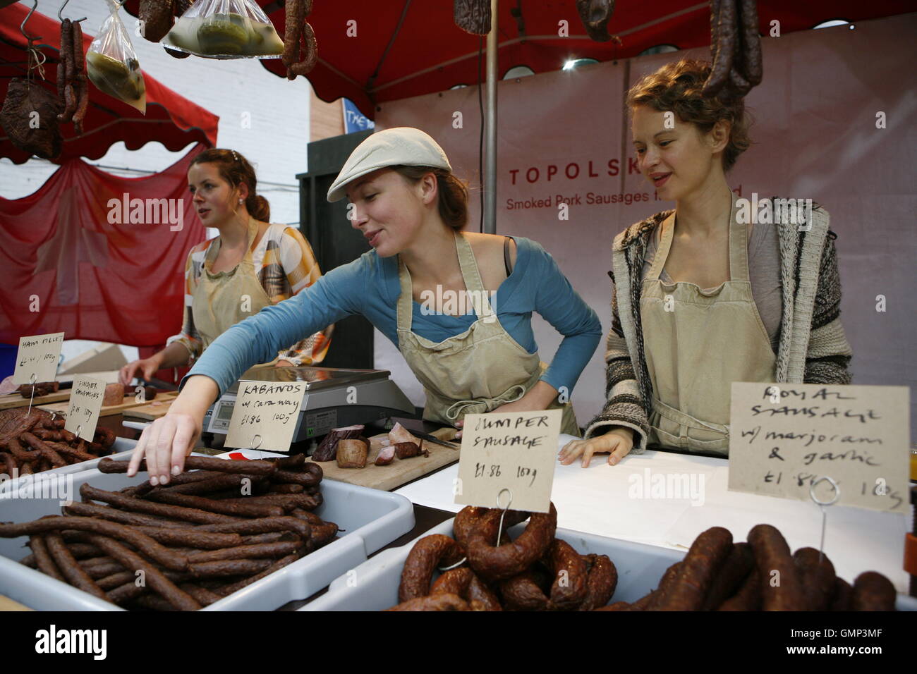 Polish girls selling Polish sausage in Borough Market, London's oldest food market situated in the borough of Southwark. Stock Photo