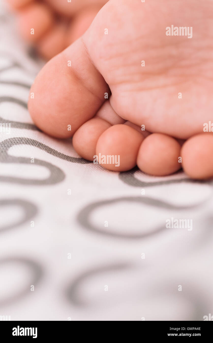 Barefoot baby on bedspread Stock Photo Alamy