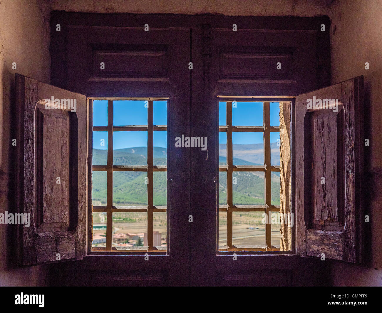 Looking Out An Interior Window With Wooden Shutters And Iron