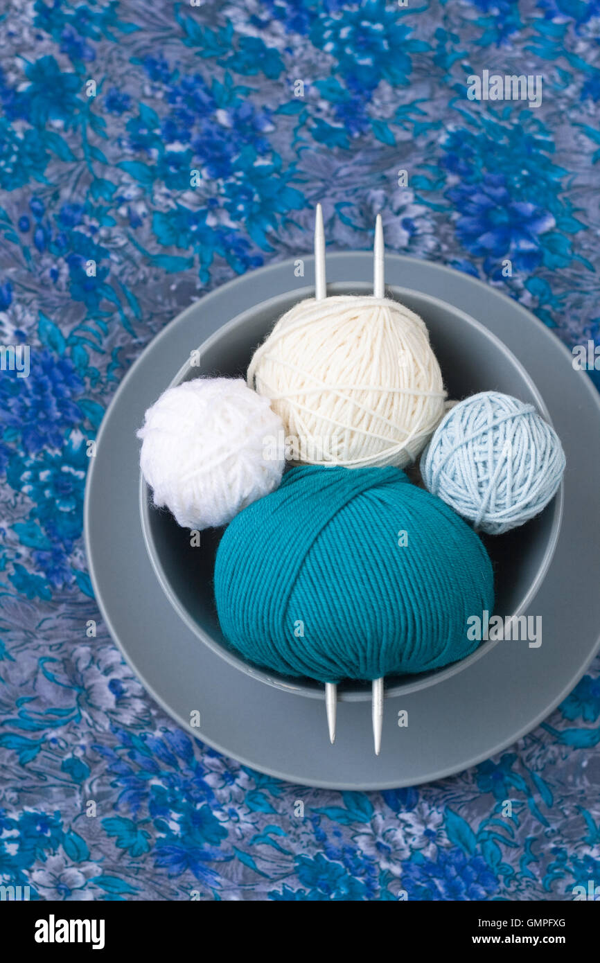 Bright balls of yarn and knitting needles on a plate Stock Photo - Alamy