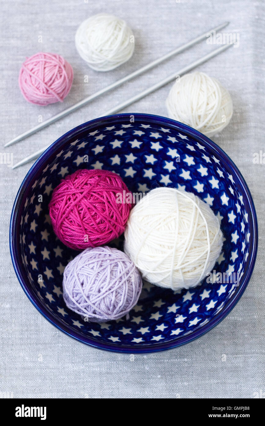 Bright balls of yarn and knitting needles on a plate Stock Photo - Alamy