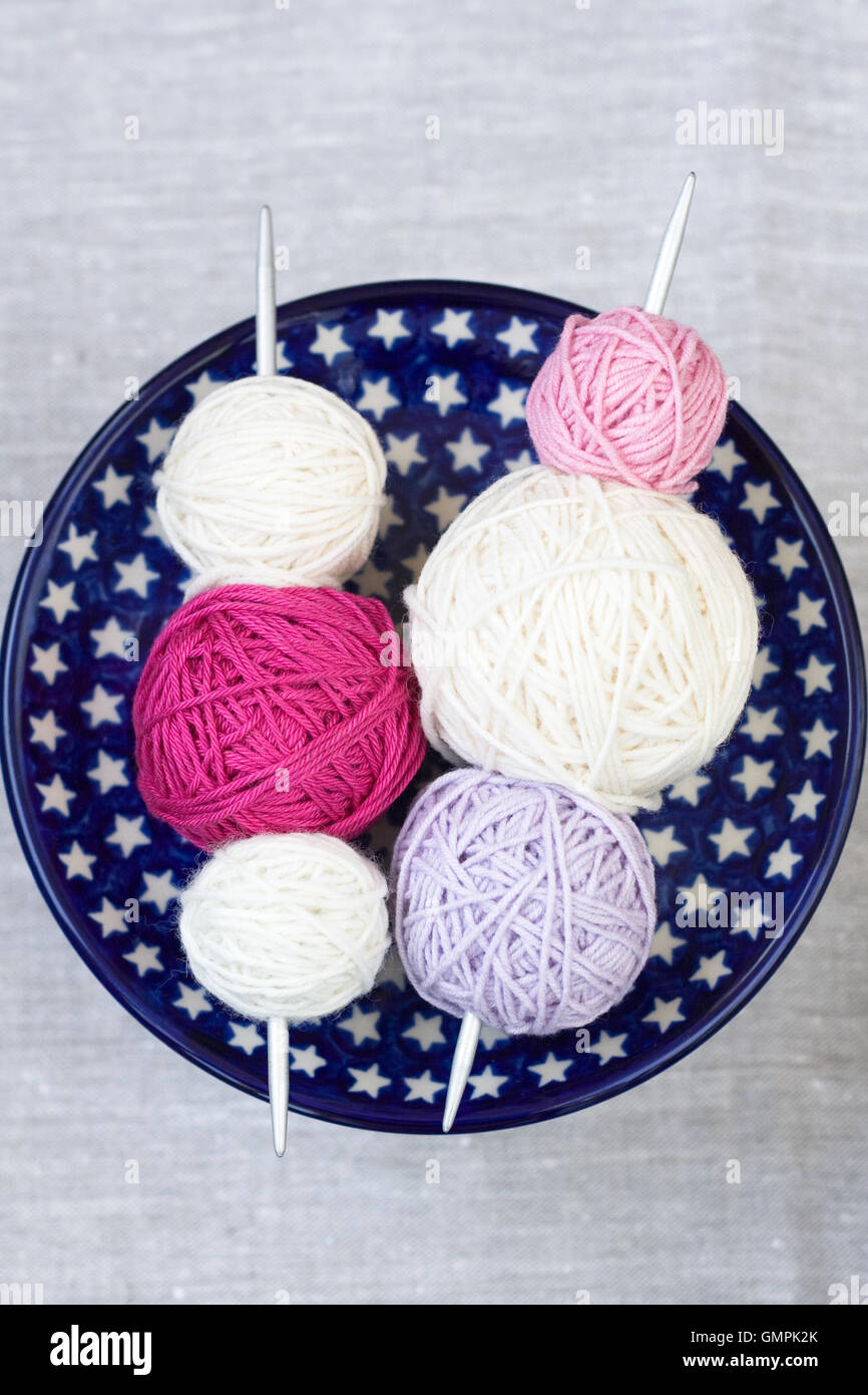 Bright balls of yarn and knitting needles on a plate Stock Photo - Alamy