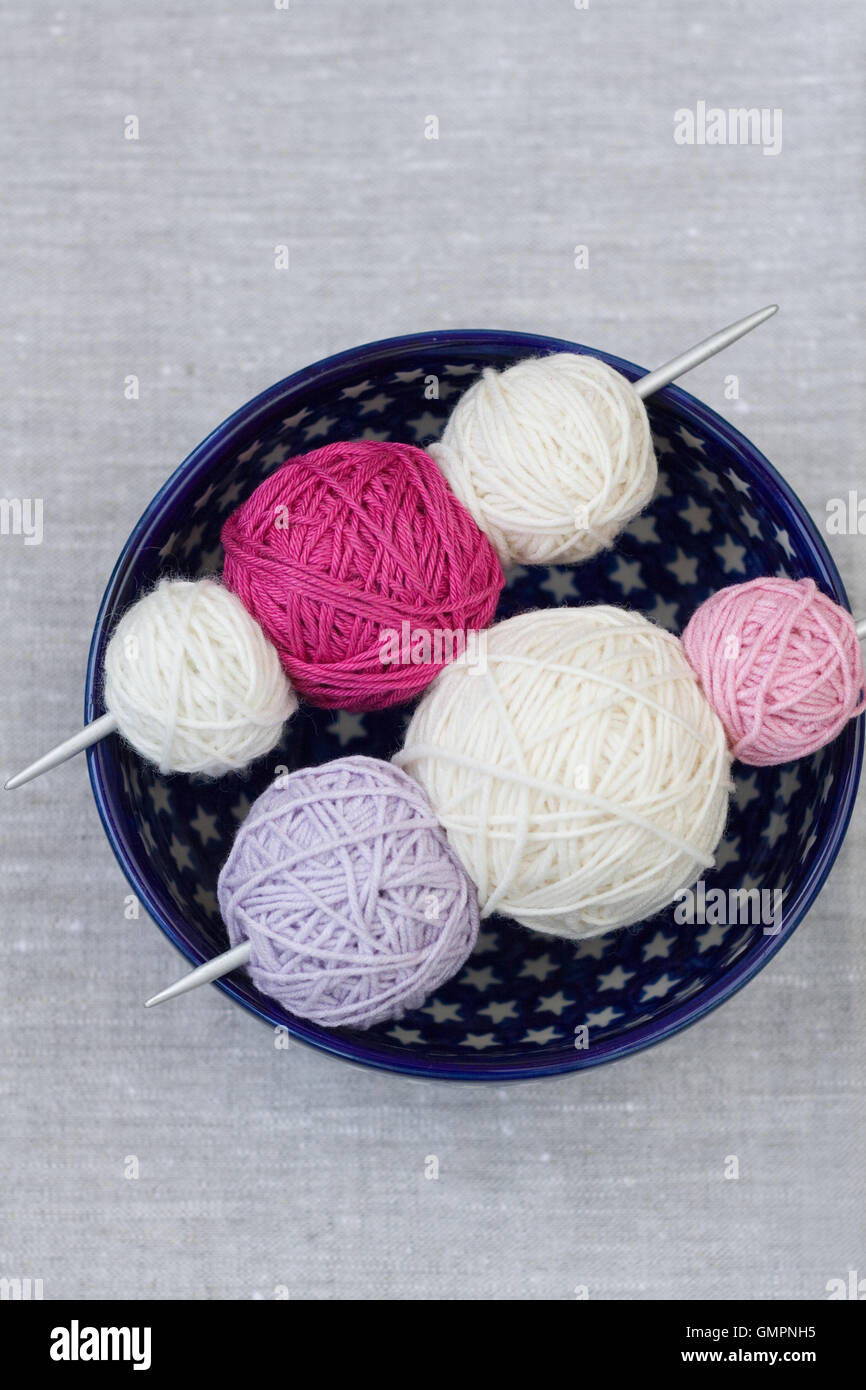 Bright balls of yarn and knitting needles on a plate Stock Photo - Alamy