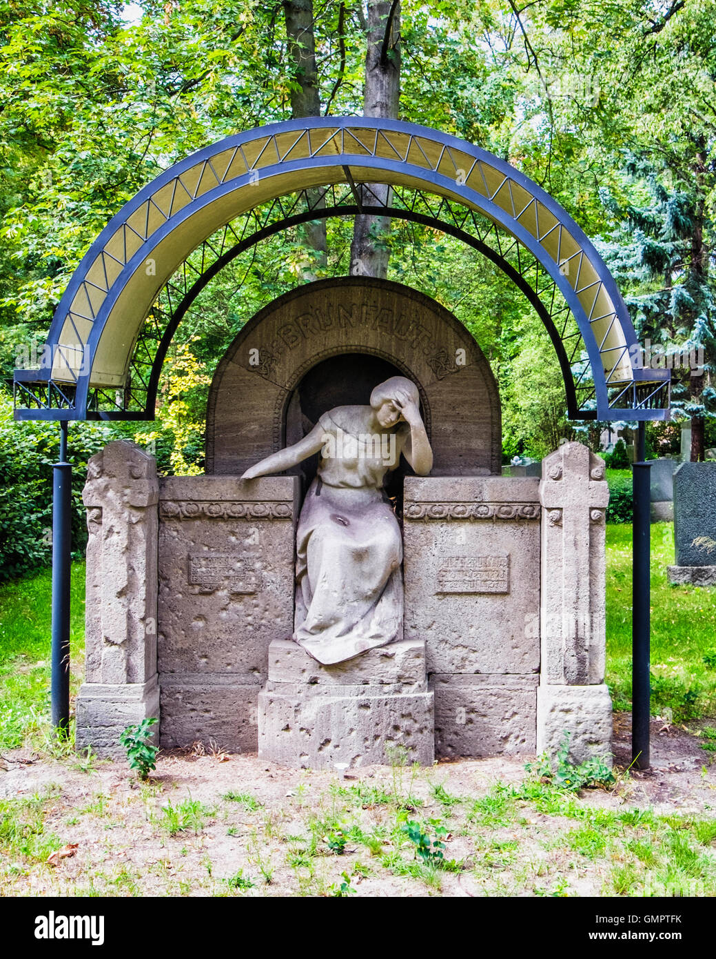 Old stone grave with sculpture of mourning woman at St. Hedwig Cemetery ...