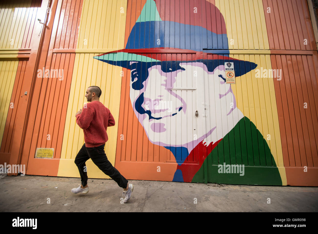 Buenos Aires, Argentina - 9 May 2016: Runner in front of a Carlos Gardel graffiti in Abastos district. Stock Photo