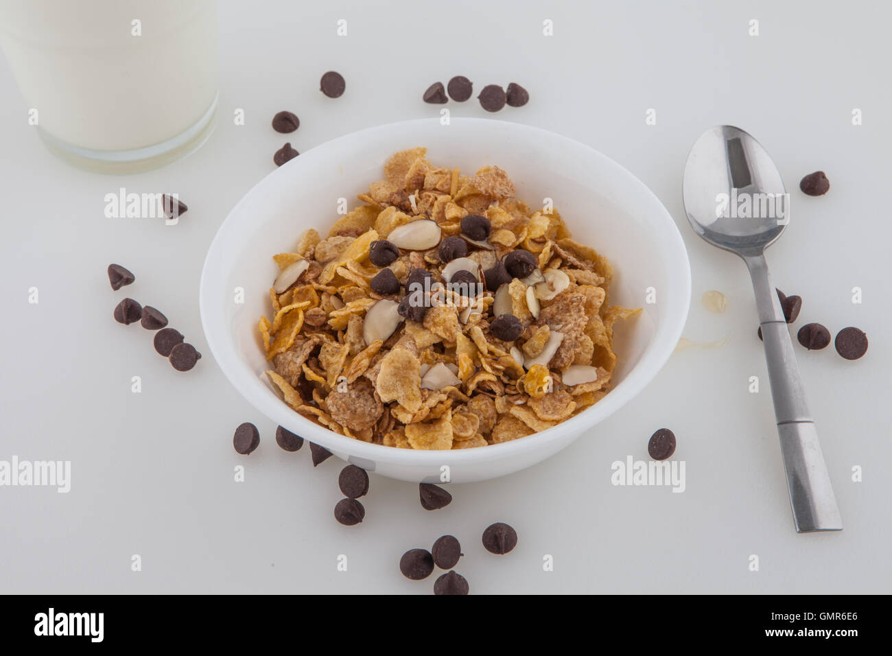 Breakfast cereal honey almond and oats chocolate chips spoon glass of milk Stock Photo