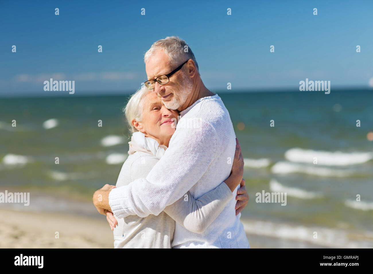 happy senior couple hugging on summer beach Stock Photo