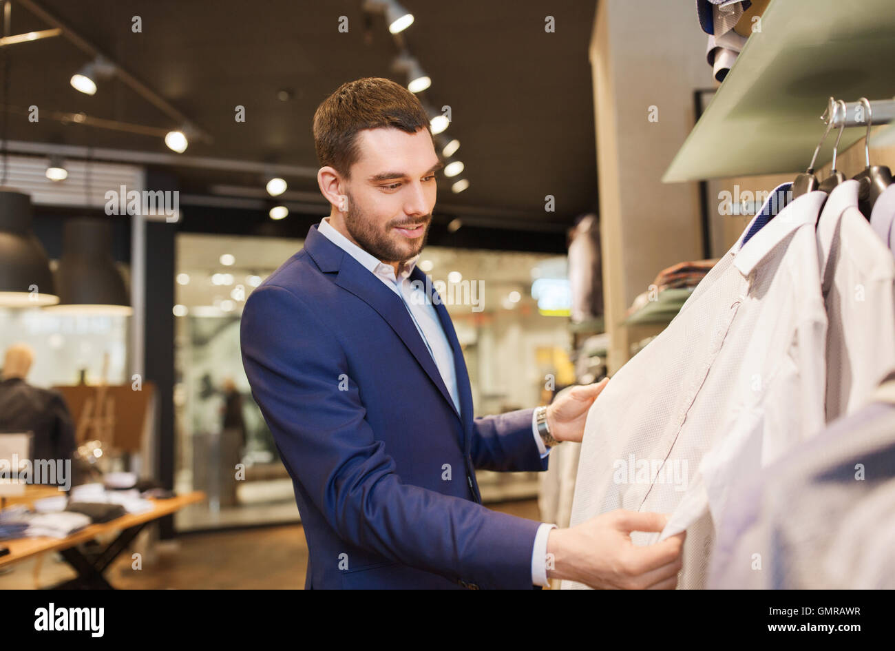 happy young man choosing clothes in clothing store Stock Photo - Alamy