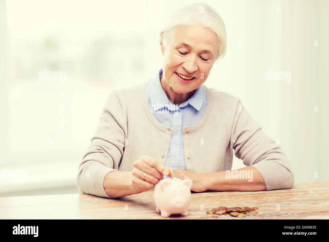 senior woman putting money to piggy bank at home Stock Photo - Alamy