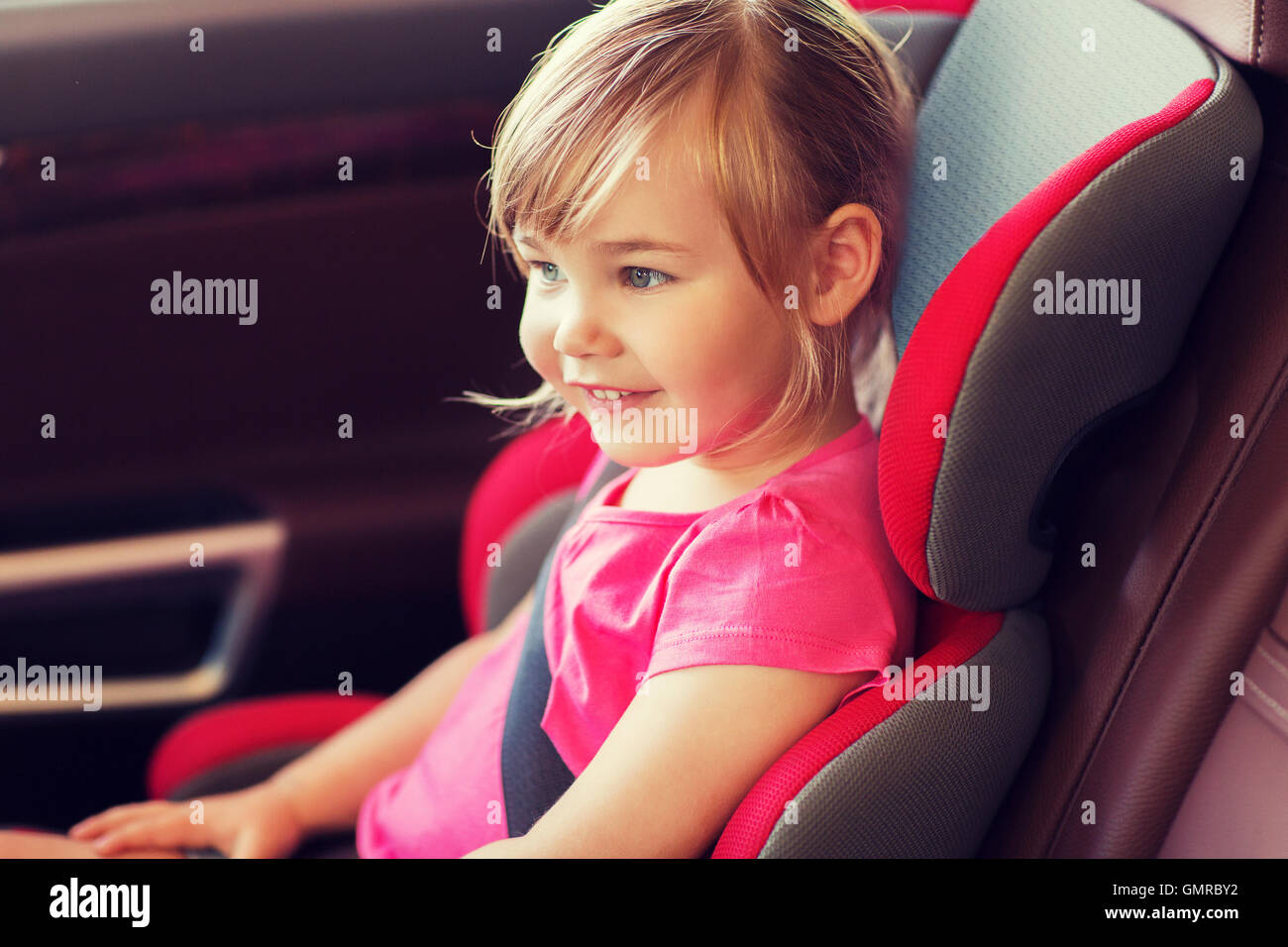 happy little girl sitting in baby car seat Stock Photo