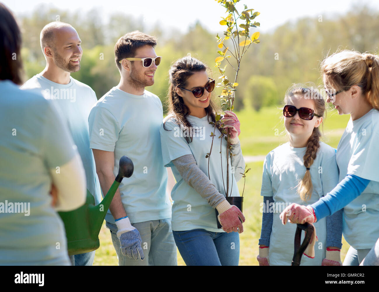 group of volunteers with trees and rake in park Stock Photo Alamy