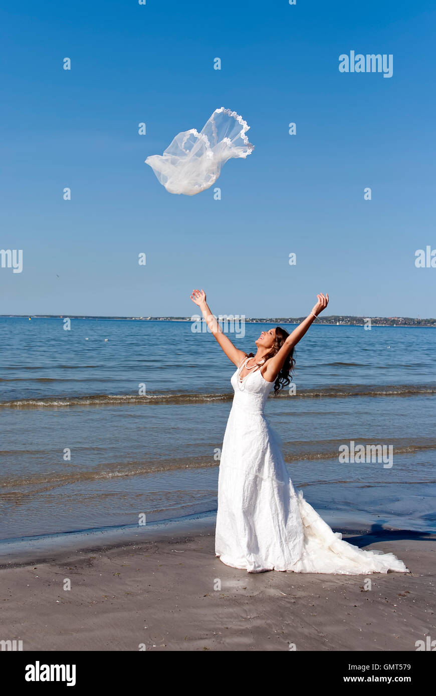 beautiful young bride throwing the veil near the sea Stock Photo - Alamy