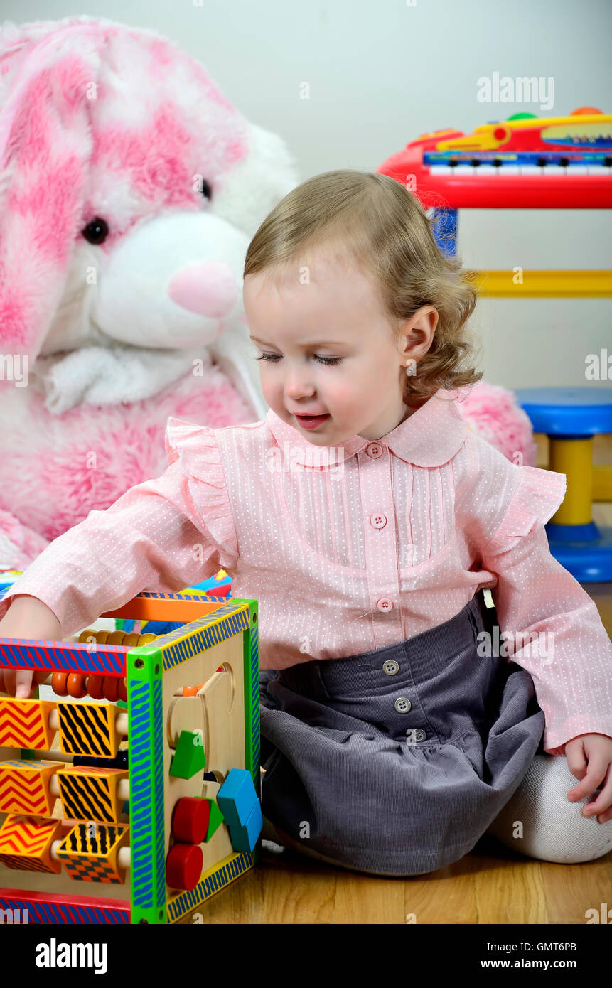 little girl in a room with toys Stock Photo - Alamy