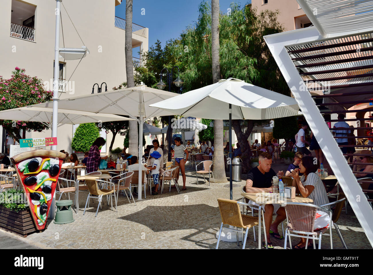 Tourists at outside pavement restaurant in Quarteira, Algarve, south Portugal Stock Photo