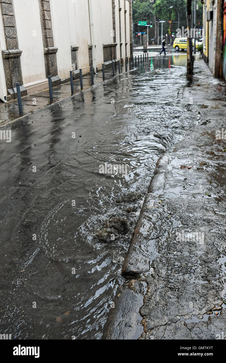 Raw sewage flows from a street drain during a rainy day in the Centro district neighborhood in Rio de Janeiro, Brazil. Stock Photo