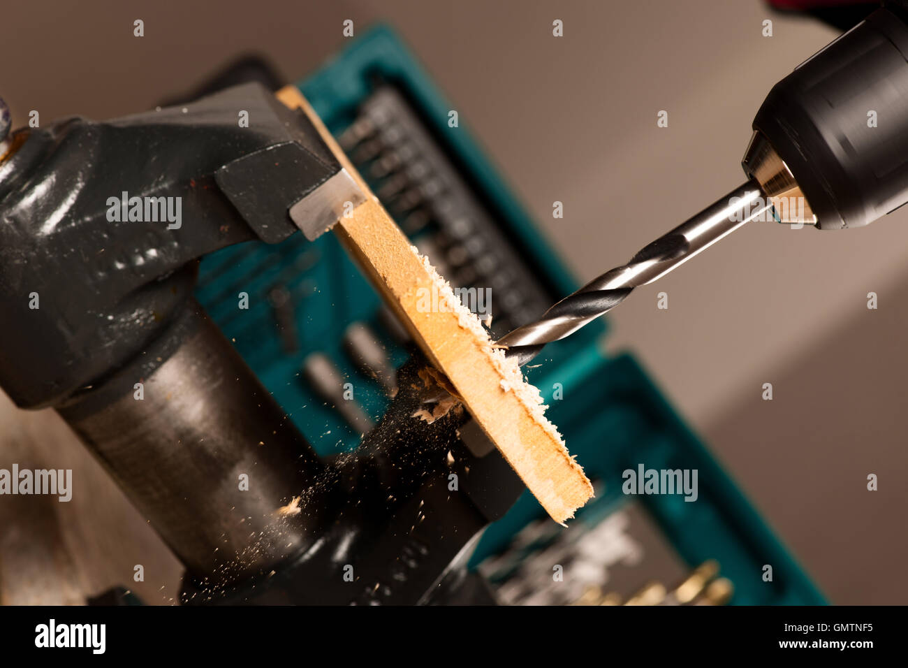 Image of drilling hole with screwdriver in wood clamped in vice tool