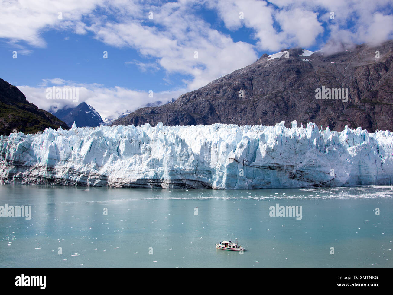 The little tourist boat getting closer to the glacier in Glacier Bay national park (Alaska). Stock Photo