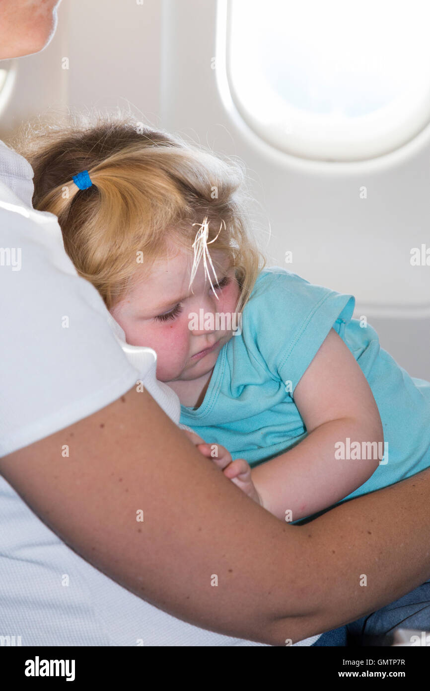 Mother Mum & kid, child, toddler, children, age 2 years, sleep asleep while flying on an air plane / airplane / aeroplane flight Stock Photo