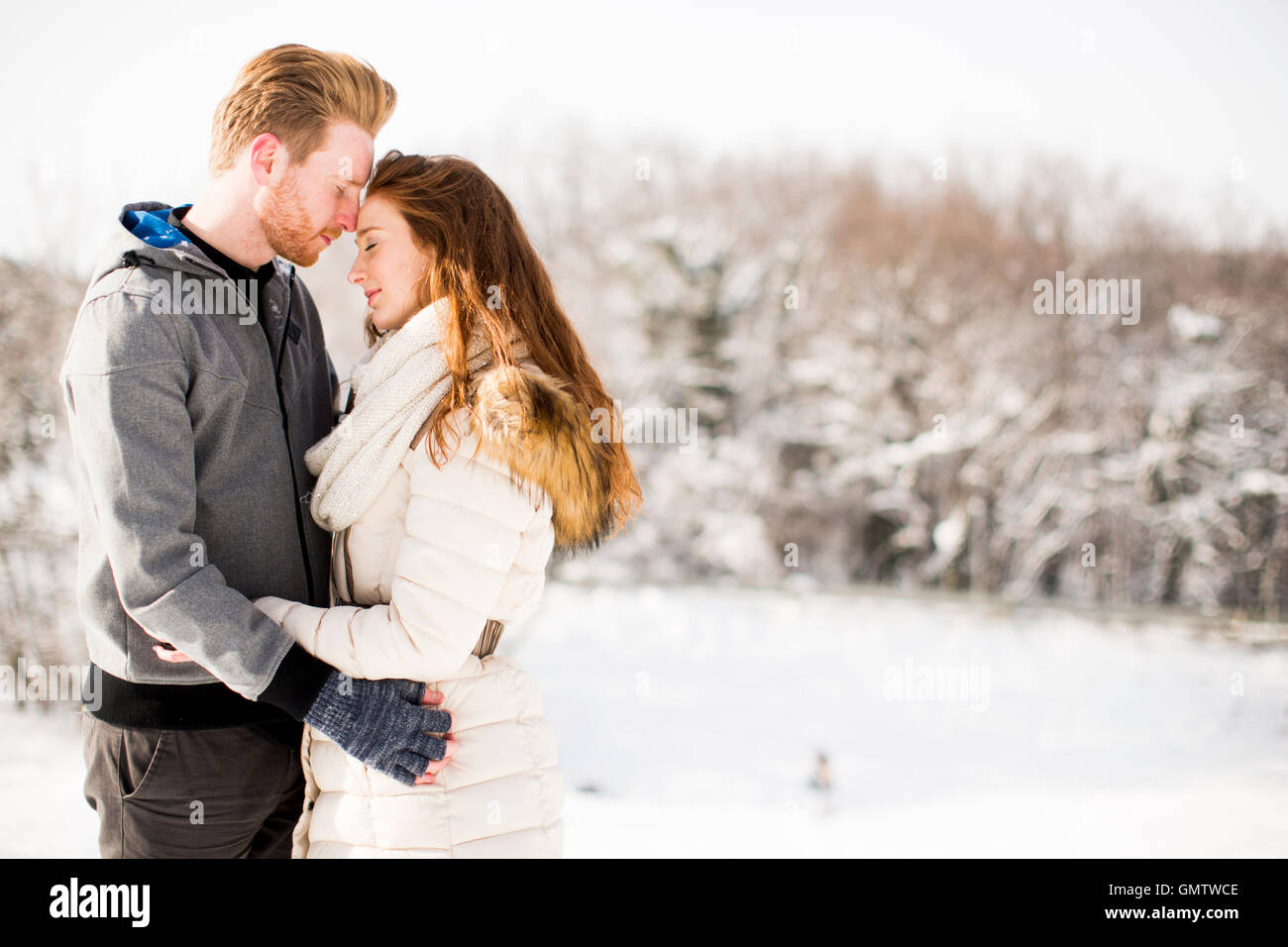 Loving young couple at winter forest Stock Photo - Alamy