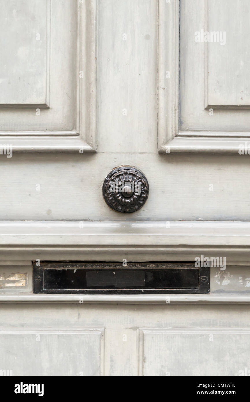 A Gray Painted Wooden Door With Black Round Door Knob And