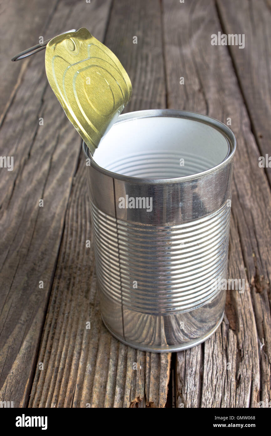 Open empty tin can on wooden background Stock Photo