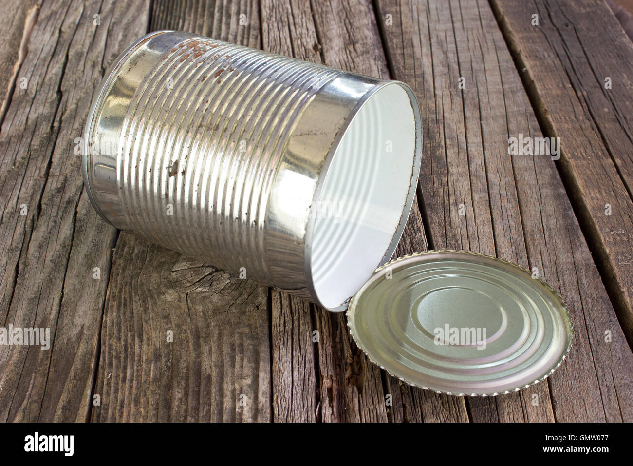 Open empty tin can on wooden background Stock Photo
