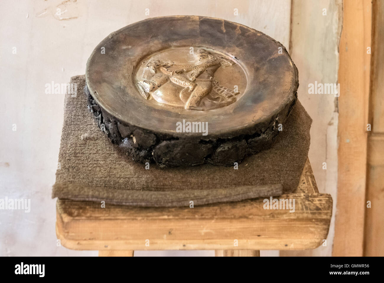 A copper plate in the process of having a traditional design hammered ...
