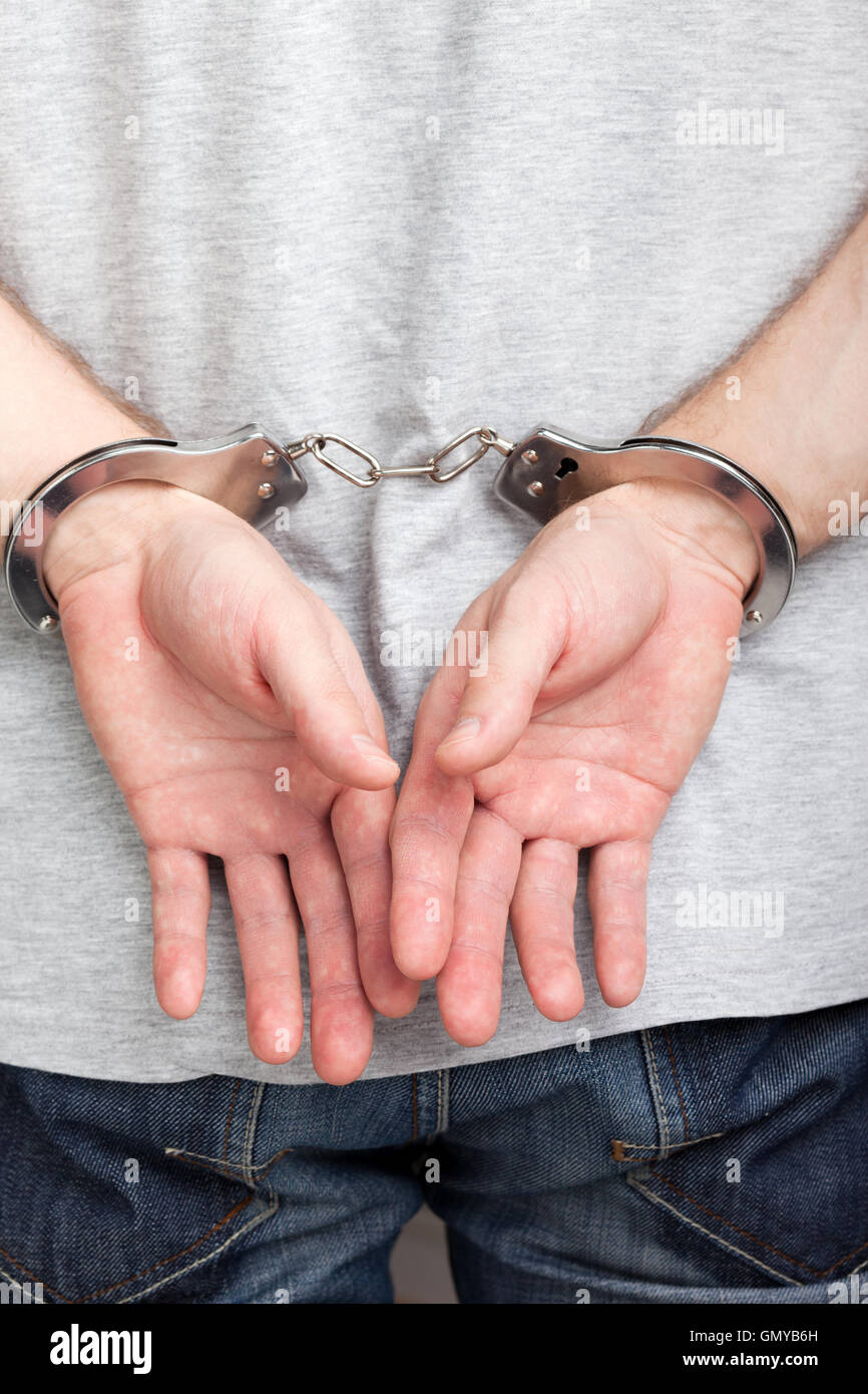 Handcuffs on hands Stock Photo Alamy