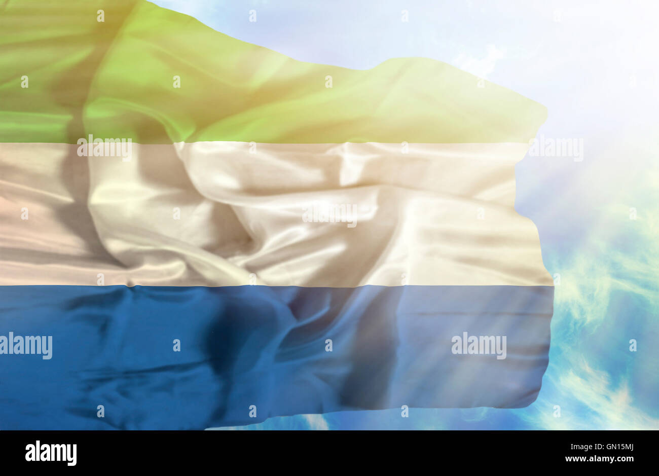 Sierra Leone waving flag against blue sky with sunrays Stock Photo - Alamy