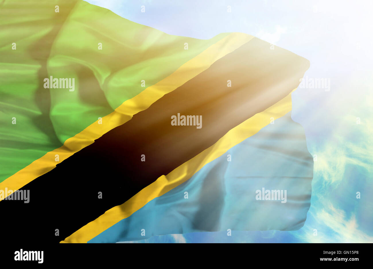 Tanzania waving flag against blue sky with sunrays Stock Photo - Alamy
